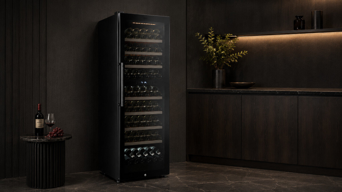 CHŁODZIARKA DO WINA BERG BRGWM193D Chłodziarka do wina BERG ustawiona w ciemnej zabudowie z podświetlanym wnętrzem i półkami wypełnionymi butelkami. Elegancki design do przechowywania kolekcji win