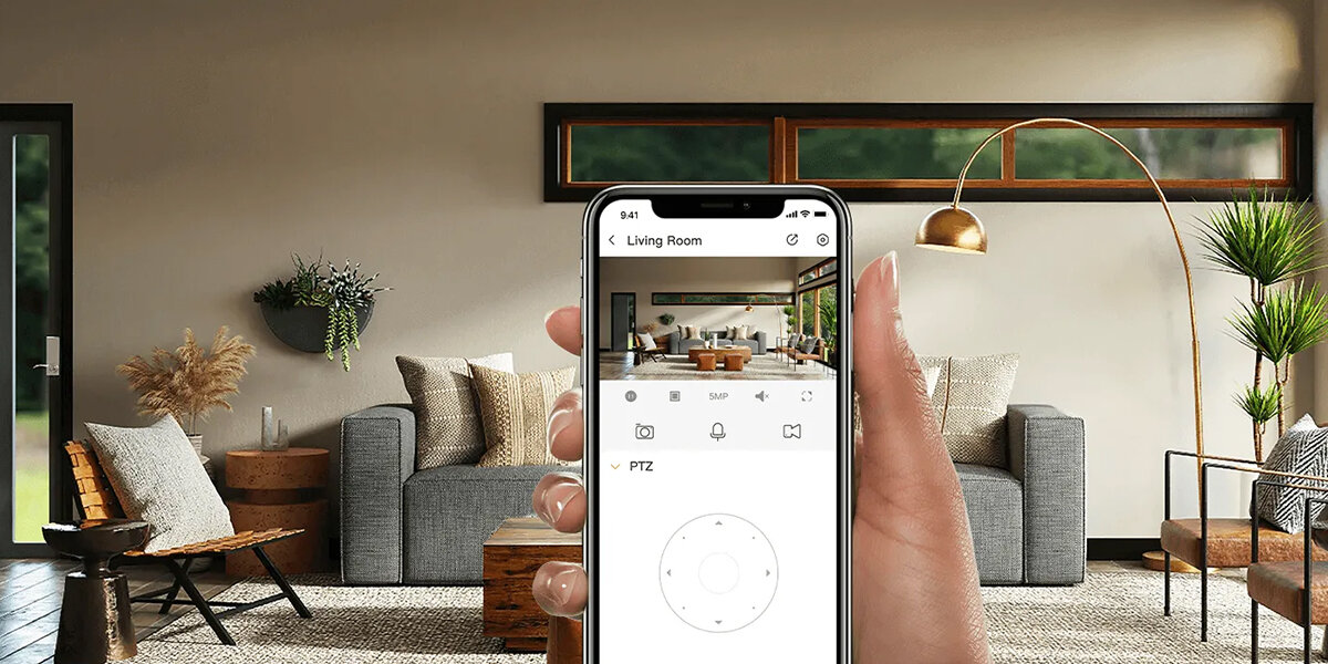 Kamera IMOU Ranger RC 5MP - Całodobowy monitoring, osoba trzymająca smartfona z obrazem z kamery, telefgon trzymany w dłoni na tle salonu