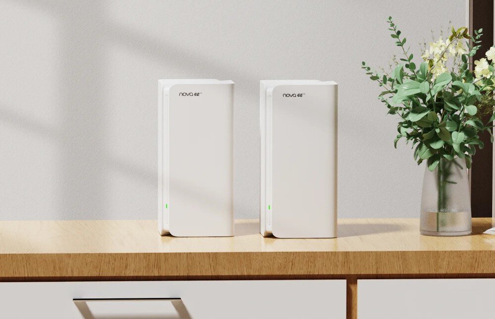 Router TENDA MX21 Pro Dwa białe routery mesh ustawione w rzędzie na jasnej drewnianej komodzie z zielonymi diodami LED świecącymi z przodu urządzeń