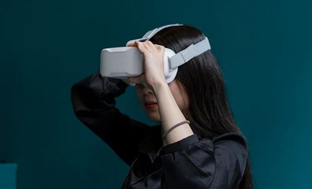 Dron BETAFPV Cetus FPV Kit Kobieta w czarnej odzieży trzymająca dłonie na założonych na głowę goglach FPV