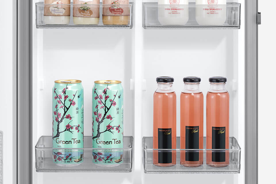Wnętrze lodówki z widocznymi półkami, na których znajdują się puszki z napisem \'Green Tea\' oraz butelki z napisem \'Fresh Juice\'.