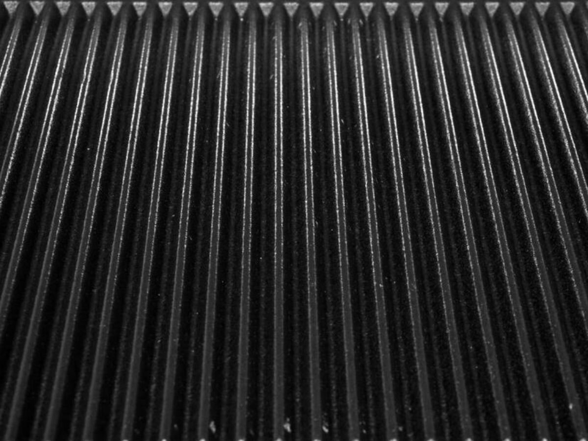 Grill elektryczny YATO YG-04560, stal, wytrzymałość, łatwość, higiena, Zbliżenie na ryflowaną powierzchnię żeliwnej płyty grillowej YATO YG-04560.