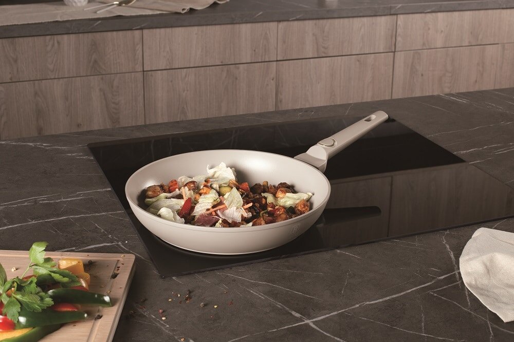 Patelnia BERLINGER HAUS Sahara Collection BH 8054 28 cm patelnia stoi na płycie kremowy kolor kremowy uchwyt złoty element potrawa w środku patelni  średnica 28 cm stylowy design praktyczność kolekcja Sahara matowy kremowy kolor stylowy wygląd funkcjonalność estetyka wygoda codziennego gotowania piękno i użyteczność 