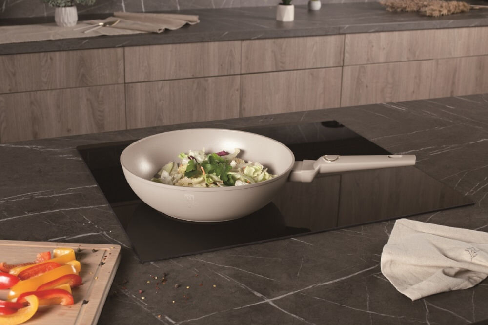Patelnia wok BERLINGER HAUS Sahara Collection BH-8063 28 cm kremowa patelnia stoi na płycie potrawa w środku złote elementy na uchwycie do każdej kuchni