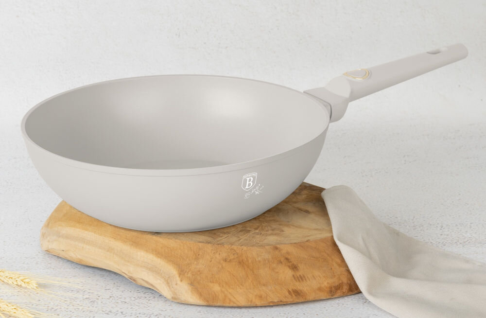 Patelnia wok BERLINGER HAUS Sahara Collection BH-8063 28 cm kremowa patelnia stoi bokiem na podstawce kremowy uchwyt złote elementy jasne tło średnica 28 cm stylowy design praktyczność kolekcja Sahara matowy kremowy kolor stylowy wygląd funkcjonalność estetyka wygoda codziennego gotowania piękno użyteczność 
