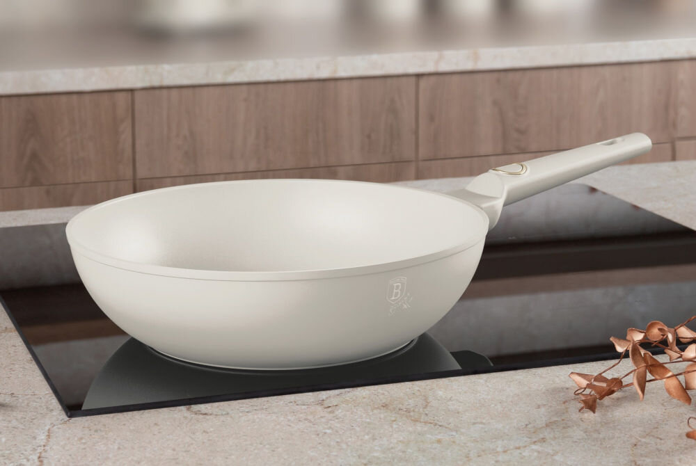 Patelnia wok BERLINGER HAUS Sahara Collection BH-8063 28 cm patelnia w kolorze kremowym stoi na płycie kremowy uchwyt złote elementy na każdym typie kuchenki gazowej, indukcyjnej, elektrycznej, ceramicznej oraz halogenowej wszechstronny sprzęt przyrządzanie różnorodnych dań uniwersalność i wygoda elegancki wygląd  