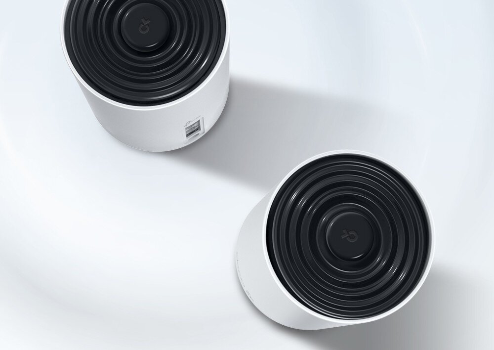 Router TP-LINK Deco XE75 Pro Dwa urządzenia w białej obudowie widziane z góry, jedno z widocznym panelem z tyłu, leżące na gładkiej, jasnej powierzchni, łączność Wi-Fi 6E, zastosowanie