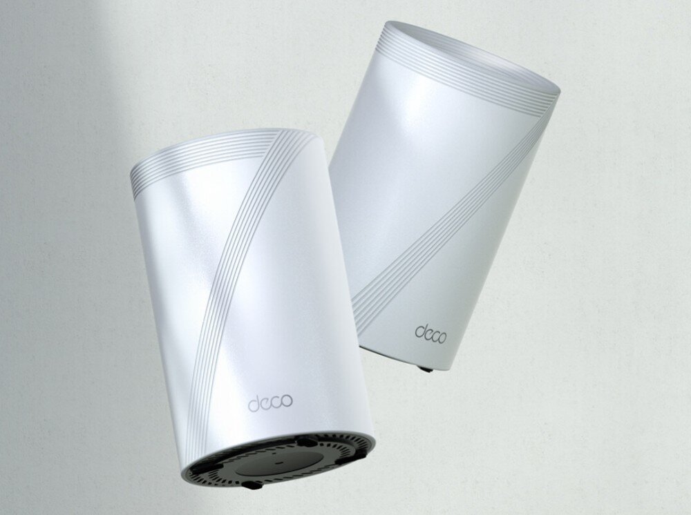 Router TP-LINK Deco BE65 Dwa cylindryczne routery w kolorze białym z subtelnym wzorem na obudowie, unoszące się w powietrzu na jasnym tle, przeznaczenie, cechy, pasma Wi-Fi, technologia