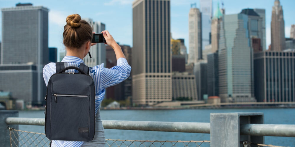 Plecak na laptopa SAMSONITE Litepoint 14,1 cali Granatowy
przemyślany design, kanciasta bryła, stonowana kolorystyka,
lekka konstrukcja ok. 800 g, kompaktowe wymiary ok. 40,5 × 28,5 × 11 cm, pojemność 16 litrów,
kobieta z założonym plecakiem, robiąca zdjęcie miasta