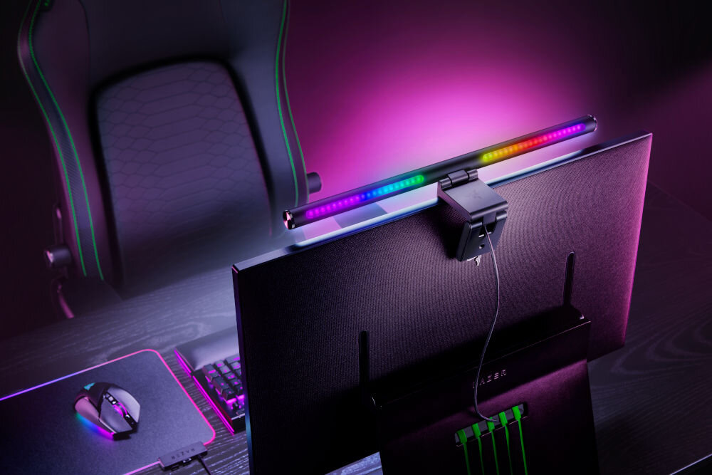 Lampka na monitor RAZER Aether Monitor Light Bar 10 W, Regulacja jasności, Wi-Fi prezentacja lampy przymocowanej do monitora na biurku i jej oświetlenia od tyłu technologia Razer Chroma™ RGB personalizacja kolorów i efektów sterowanie aplikacją tworzenie klimatu