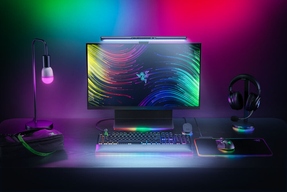 Lampka na monitor RAZER Aether Monitor Light Bar 10 W, Regulacja jasności, Wi-Fi prezentacja lampy przymocowanej do monitora na biurku i jej oświetlenia od przodu dopasowanie do monitorów różnych rozmiarów i kształtów szybki montaż stabilność wygodne funkcjonalne oświetlenie
