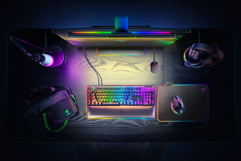 Lampka na monitor RAZER Aether Monitor Light Bar 10 W, Regulacja jasności, Wi-Fi prezentacja lampy przymocowanej do monitora na biurku i jej oświetlenia od góry Razer Game Room dedykowana aplikacja zarządzanie urządzeniami dostosowanie ustawień tworzenie harmonogramów automatyzacja zintegrowany ekosystem