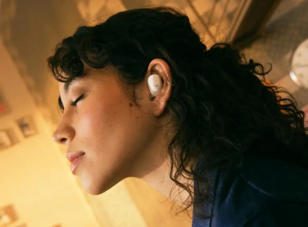Słuchawki dokanałowe SENNHEISER Accentum True Wireless ANC Kobieta z zamkniętymi oczami i słuchawką w uchu wygląda, jakby wczuwała się w muzykę, łączność Bluetooth, funkcje, sterowanie