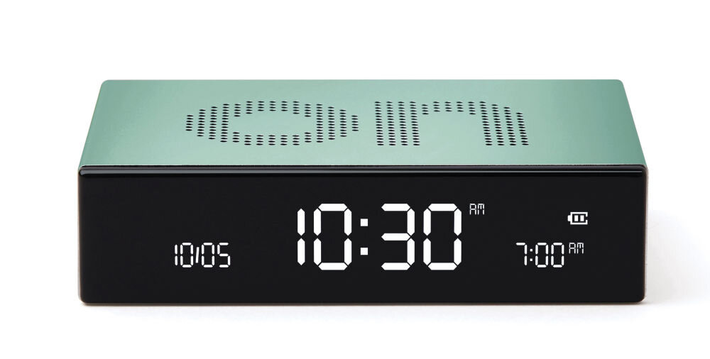 Budzik z miętową obudową i wyświetlaczem cyfrowym pokazującym godzinę 10:30 AM oraz ustawiony alarm na 7:00 AM. Na górze obudowy widoczny jest perforowany napis \'ON\'.