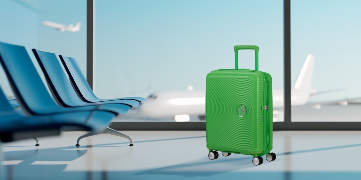 Walizka AMERICAN TOURISTER SoundBox 55 cm lifestyle lotnisko tło szyba Komfortowe podróżowanie i bezpieczeństwo bagażu Wygoda i funkcjonalność twarda konstrukcja możliwość poszerzenia zwiększenie przestrzeni z 71,5 na 81 l wbudowany 3 cyfrowy zamek bezpieczeństwo ochrona bagażu bezpieczeństwo wymiary 55 x 40 x 20/23 cm