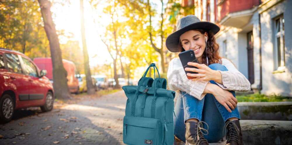 Plecak na laptopa AMERICAN TOURISTER Urban Groove UG25 Roll-Top 15.6 cali Breeze Blue Niebieski
W modnym miejskim stylu, kobieta siedząca na murku, a obok niej plecak