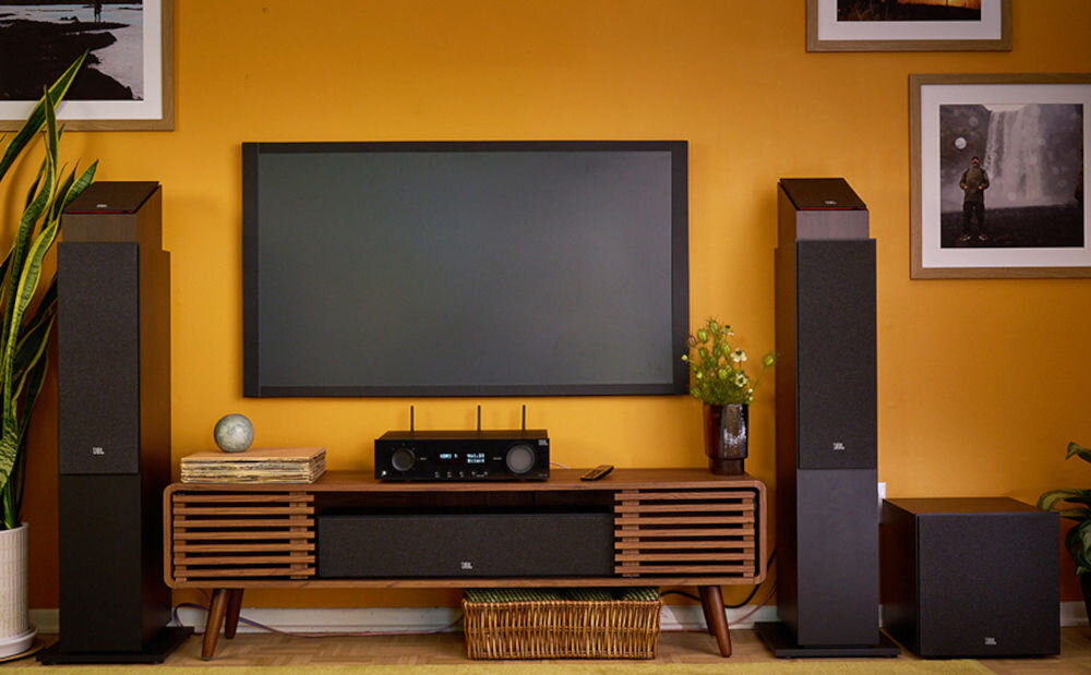 Amplituner JBL MA710 minimalistyczny design kompaktowy wygląd, amplituner stojący na komodzie pod zawiesoznym telewizorem