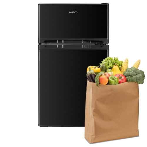 Lodówka MPM-87-CZ-15/E, obok torba wypełniona warzywami i owocami.