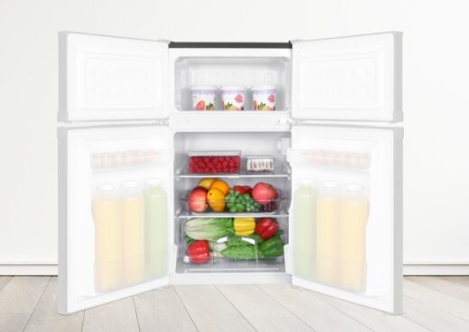 Otwarta lodówka MPM-87-CZ-15/E wypełniona produktami. Półprzezroczyste drzwi lodówki po obu stronach.