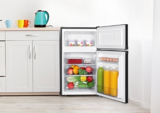 Otwarta lodówka MPM-87-CZ-15/E wypełniona produktami w kuchni.