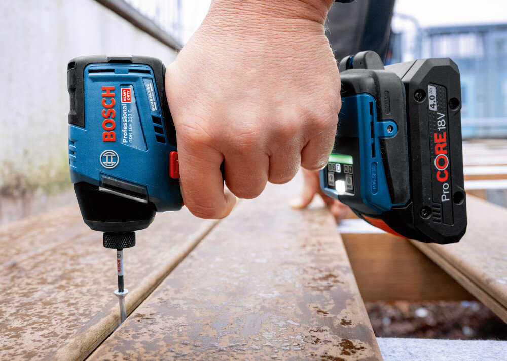 Klucz udarowy BOSCH Professional GDR 18V-220 C 06019L6000 podest osoba przykręca śrubkę między deskami mechanizm udarowy do 4000 uderzeń na minutę trzy poziomy pracy: 0–1500, 0–3400 oraz 0–4000 ud./min można dopasować intensywność do materiału zmniejsza to ryzyko uszkodzenia łbów i gwintów