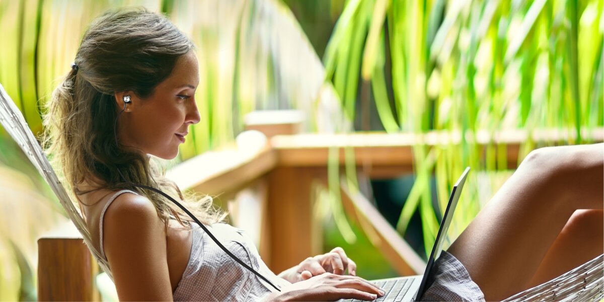 Słuchawki douszne HAMA Ocean II - Słuchaj i kontroluj, kobieta sluchająca muzyki przez słuchawki i używająca laptopa