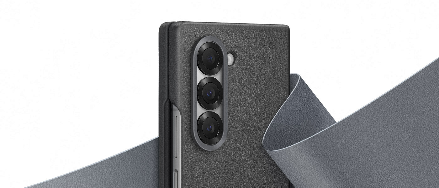 Zbliżenie na górną połowę Galaxy Z Fold6 w szarym etui Kindsuit. Za telefonem znajduje się płynna próbka miękkiego materiału ze skóry wegańskiej, która owija się wokół tylnej części telefonu, podkreślając luksusowy wygląd obudowy. Zbliżenie na górną połowę Galaxy Z Fold6 w szarym etui Kindsuit. Za telefonem znajduje się płynna próbka miękkiego materiału ze skóry wegańskiej, która owija się wokół tylnej części telefonu, podkreślając luksusowy wygląd obudowy.