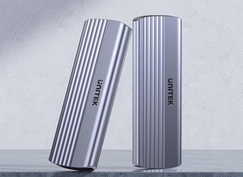 Obudowa dysku UNITEK S1241B01 Dwie srebrne, podłużne obudowy na dysk z pionowymi żłobieniami i napisem 'UNITEK', jedna stoi prosto, a druga jest o nią lekko oparta na jasnym tle