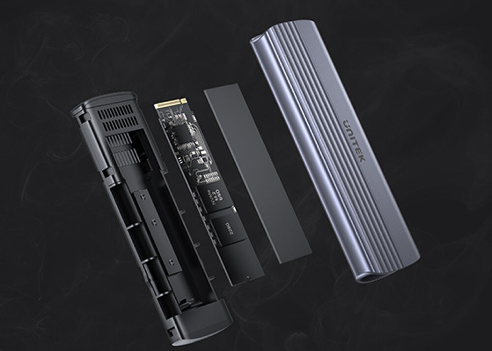 Obudowa dysku UNITEK S1241B01 Rozłożona na części obudowa na dysk pokazująca czarną podstawę z otworami wentylacyjnymi, płytkę elektroniczną dysku SSD, szarą podkładkę termiczną oraz zewnętrzną, srebrną pokrywę ze żłobieniami na czarnym tle z efektem dymu