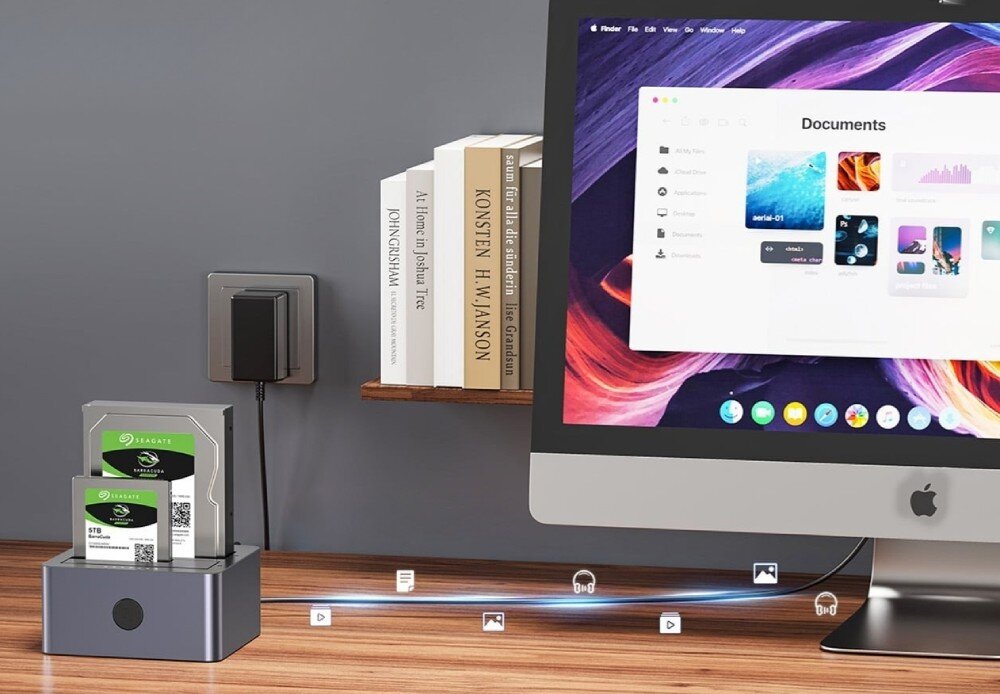 Stacja dokująca UNITEK Y-3027GY01-EU Stanowisko komputerowe z monitorem i podłączoną stacją dysków, z wizualizacją transferu plików muzycznych i wideo