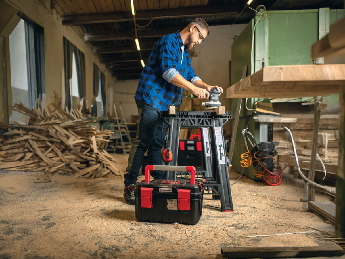 Stojak-kobyłka warsztatowa KISTENBERG  TECH STAND KTS8060, wytrzymałość, stabilność, konstrukcja, bezpieczeństwo, Stolarz szlifujący deskę na kozłach w warsztacie