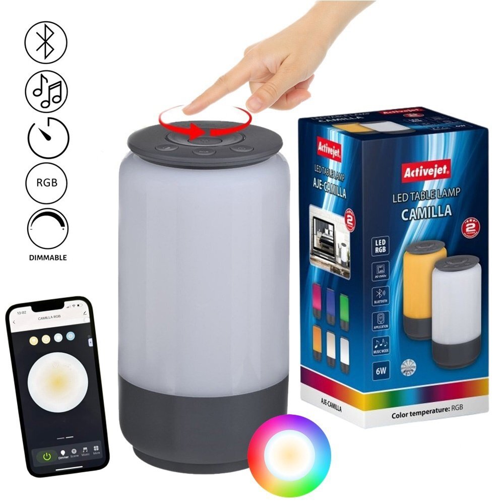 Obraz przedstawia dekoracyjną lampę stołową LED z funkcją RGB i możliwością ściemniania, obok której znajduje się opakowanie z logo Activejet. Na opakowaniu widnieje napis \'LED TABLE LAMP CAMILLA\', a obok lampy pokazany jest smartfon z aplikacją do sterowania lampą.