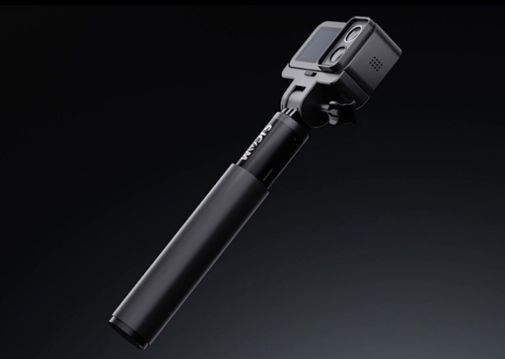 Kamera sportowa SJCAM SJ20 + Akumulatorowy uchwyt do kamery port USB-C Czarna kamera sportowa zamocowana na czarnym wysięgniku na ciemnym tle