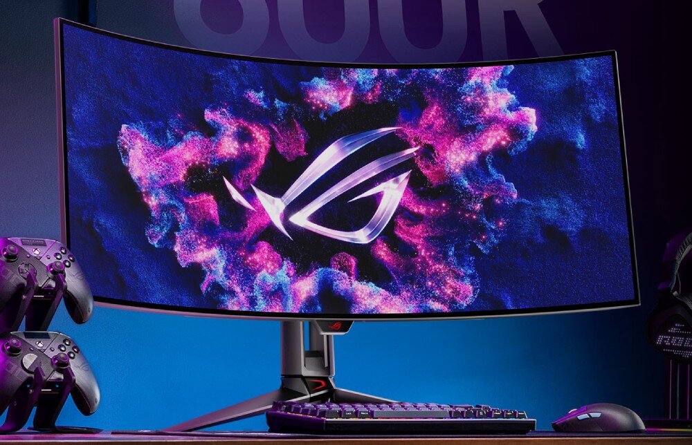 Monitor ASUS ROG Swift PG39WCDM Monitor na biurku w przyciemnionym pomieszczeniu, wyświetlający grafikę w stylu neonowego pinballa z elementami nawiązującymi do sprzętu komputerowego, czas reakcji, odświeżanie, płynność, synchronizacja FreeSync i G-SYNC