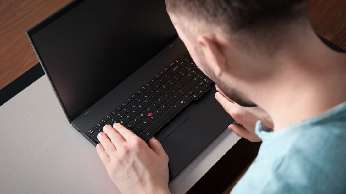 Laptop LENOVO ThinkPad L16 Gen 1 i mężczyzna pochylony nad nim. Intel Core Ultra Sztuczna inteligencja