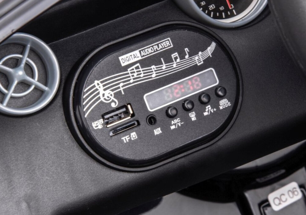 Samochód dla dziecka MILLY MALLY Mercedes-Benz SLC Czarny zbliżenie na panel multimedialny panel multimedialny z gniazdem AUX, USB-A i wejściem na kartę SD multimedialna kierownica z klaksonem i 5 melodiami dostosowanie głośności przytrzymać przez około 3 sekundy klawisz przewijania „V+” głośniej lub „V-” ciszej kierownica zasilana jest przez akumulator