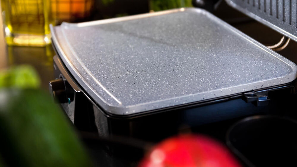 Grill elektryczny CECOTEC Rock'nGrill 2000 Stone Ceramic Mix&Grill kluczowy element ceramiczna powłoka RockStone Ceramic trwała ceramika nieprzywieranie potraw ułatwienie czyszczenia pozostaje w doskonałym stanie niezawodne działanie komfort użytkowania  