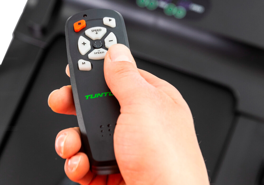 Bieżnia elektryczna TUNTURI Cardio Fit T10 1650W 12km-h pilot zdalnego sterowania zasilanie dwie baterie typu AAA praktyczny uchwyt na pilota wygodne przechowywanie latwy dostep do sterowania