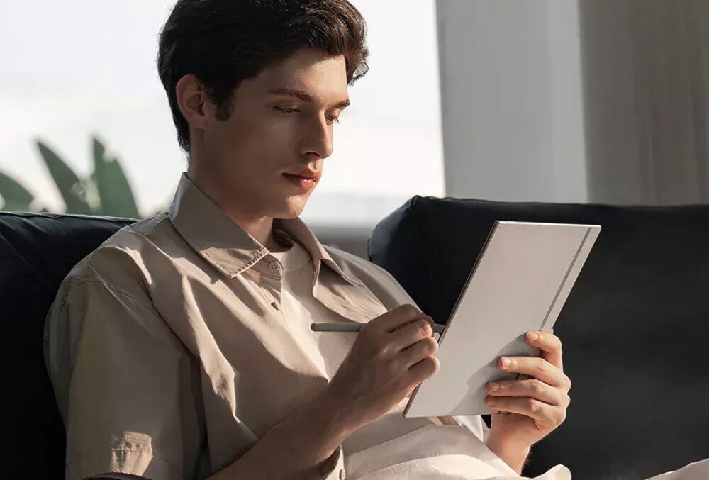 Czytnik e-booków ONYX BOOX Go Mężczyzna siedzący na kanapie, trzymający czytnik. W dłoni ma rysik, którym wykonuje notatki na ekranie, wymiary, waga, mobilność