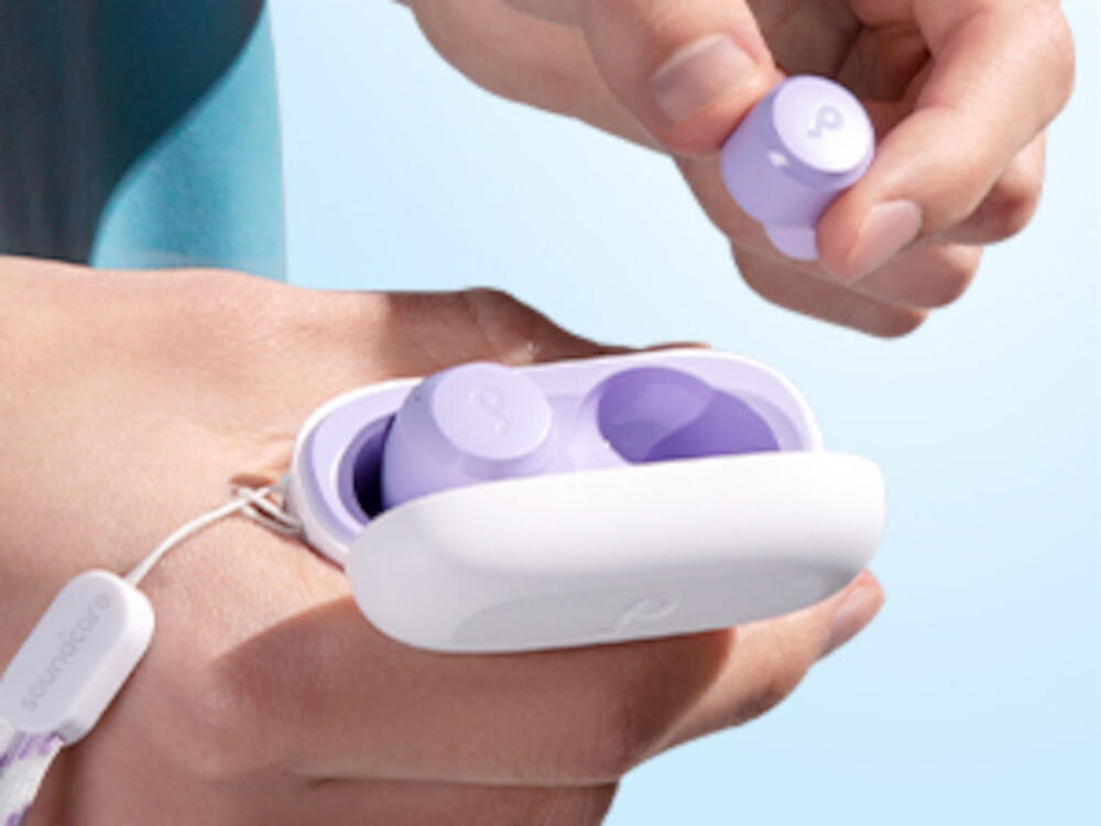 Słuchawki dokanałowe SOUNDCORE A25i bezprzewodowe Bluetooth komfortowe lekkie, osoba trzymająca słuchawki z etui ładującym w rękach