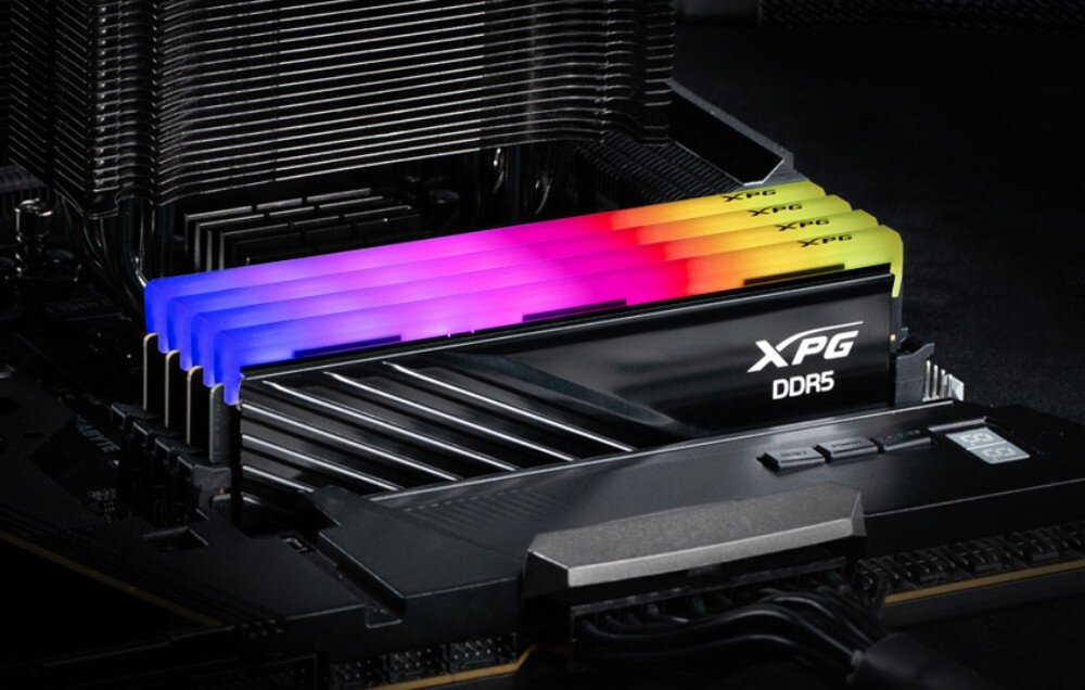Pamięć RAM ADATA XPG Lancer Blade RGB Moduł pamięci DDR5 z czarnym radiatorem zainstalowany obok coolera procesora, z widocznym wielokolorowym podświetleniem RGB na górnej krawędzi