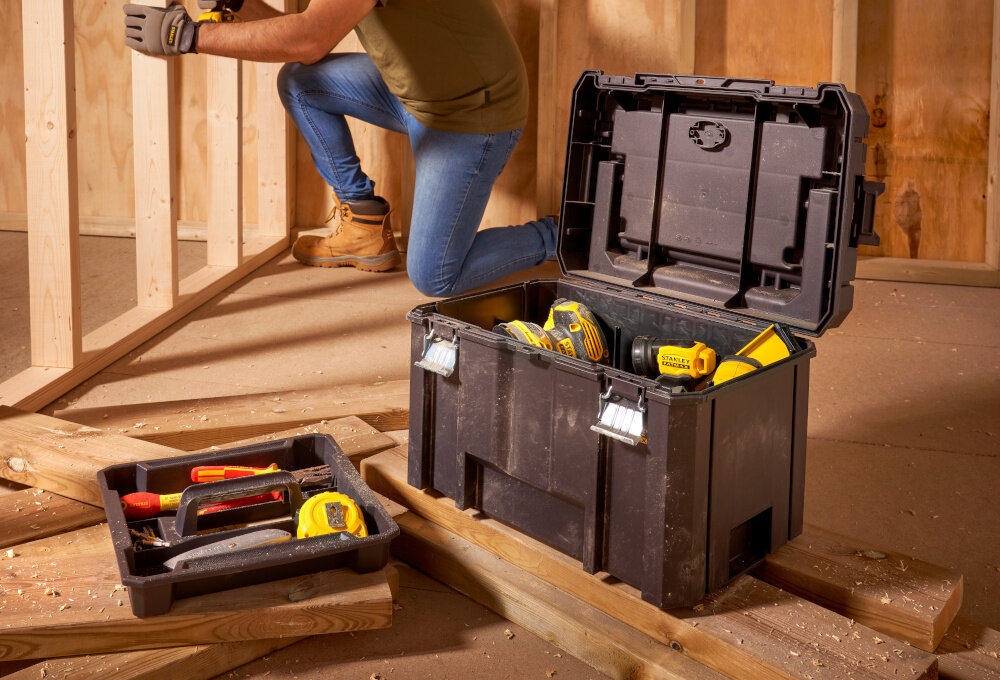 Skrzynka narzędziowa STANLEY Fatmax TSTAK FMST1-75796 pomieszczenie skrzynka i tacka ustawiona na drewnianych elementach wypełniona narzędziami porządek transport mobilność przenoszenie narzędzi