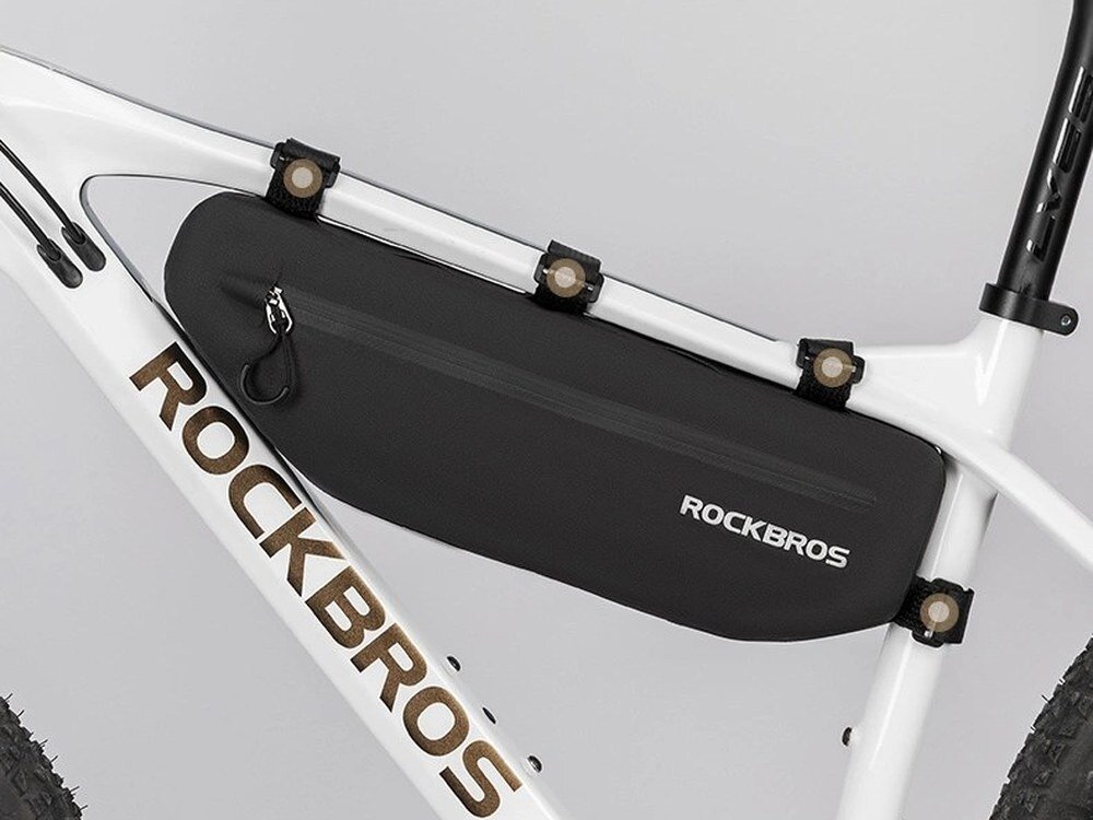 Torba rowerowa ROCKBROS AS-043, rzepy, montaż, dopasowanie, stabilność, Czarna sakwa zamontowana pod ramą białego roweru.
