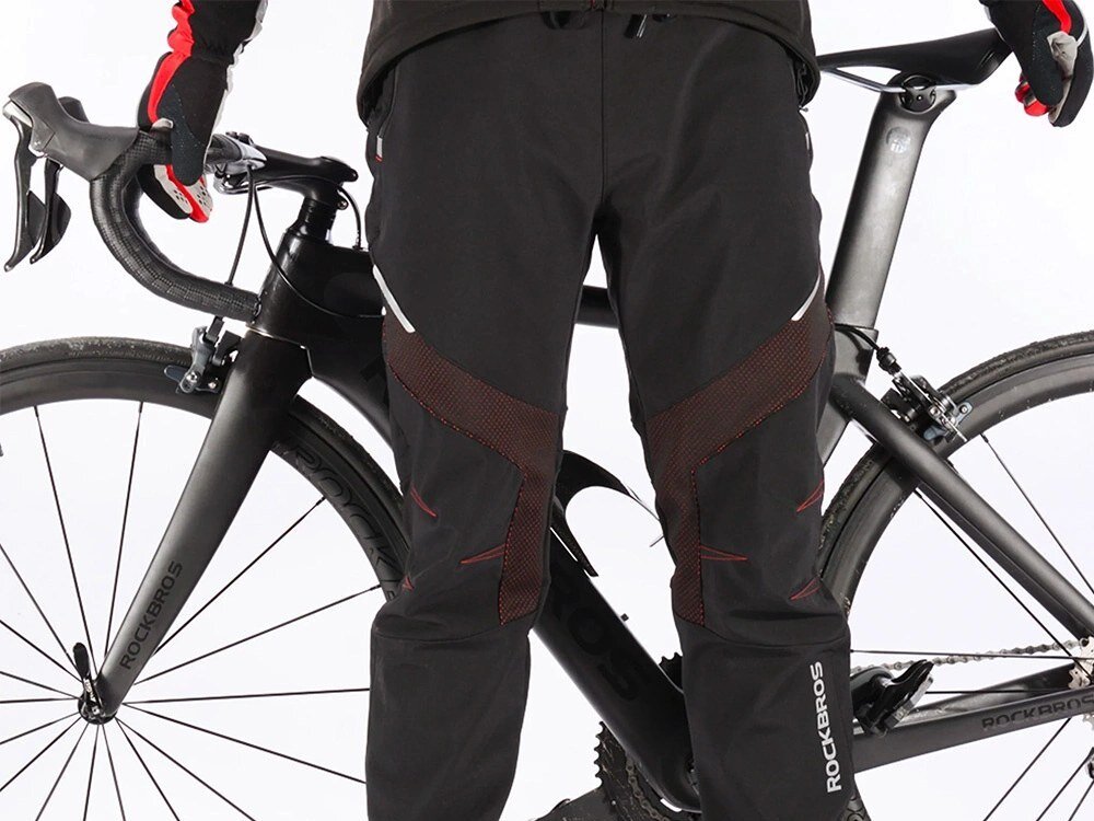 Spodnie rowerowe ROCKBROS YPK1007R (rozmiar XL) Czarny, Wentylacja, oddychalność, komfort, suchość, Mężczyzna w czarnym stroju sportowym obok roweru.