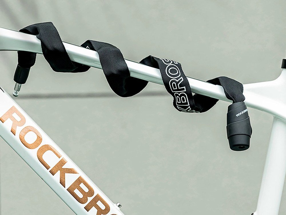 Zapięcie rowerowe ROCKBROS 3230002001, 0,95 m, elastyczność, dopasowanie, funkcjonalność, Łańcuch owinięty wokół ramy białego roweru.