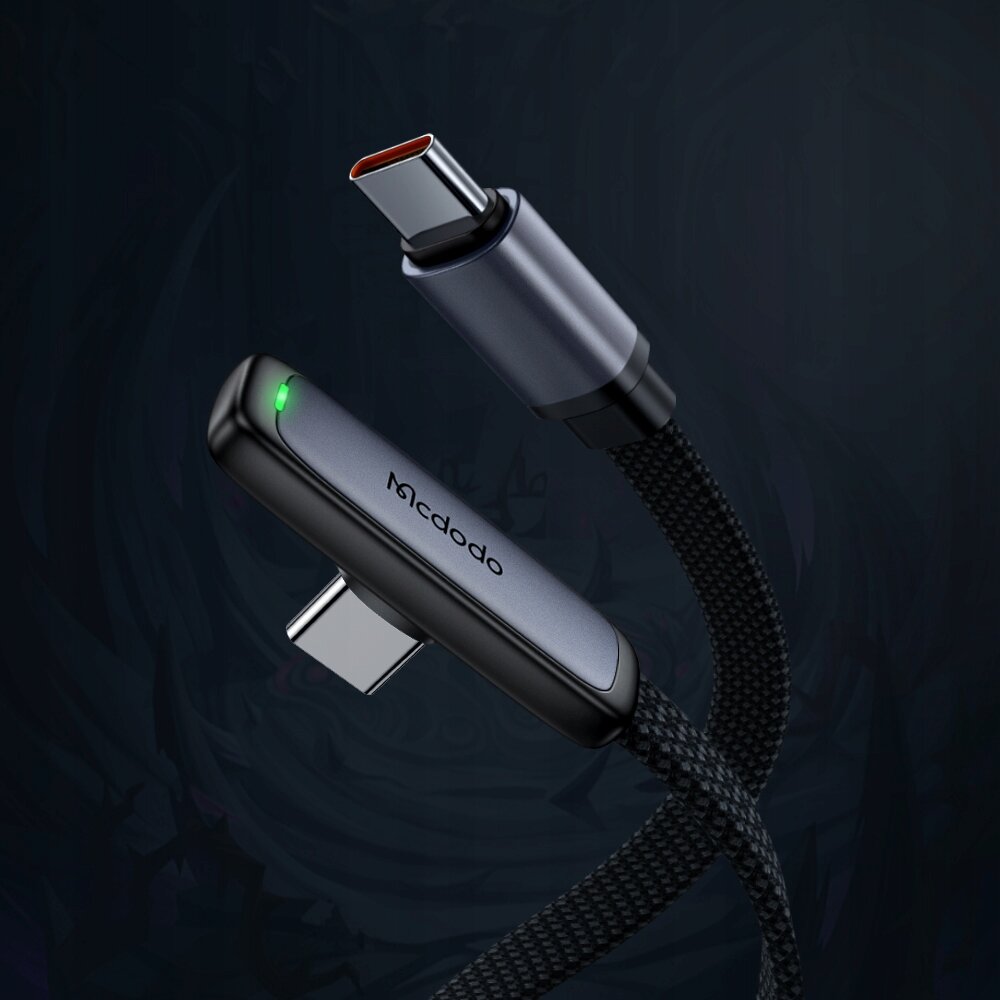 Na ciemnym tle widoczny jest czarny kabel USB-C z kątową końcówką, na której znajduje się zielona dioda. Na obudowie kabla widnieje napis \'Mcdodo\'.