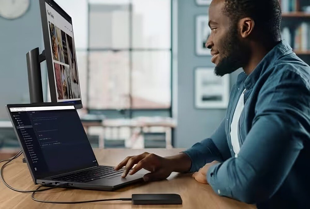 Projektant korzystający z laptopa ThinkPad podłączonego do monitora z portfolio graficznym, środowisko pracy programisty -  przeznaczenie procesor funkcje technologia NPU