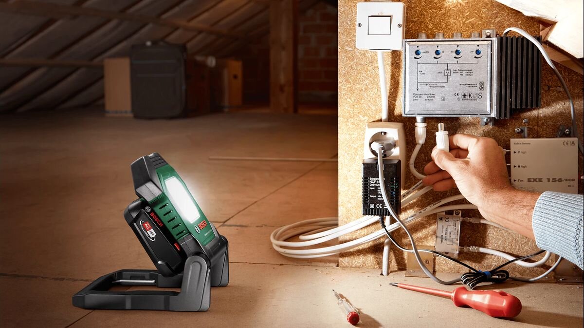Lampa warsztatowa BOSCH UniversalWorkLight 18V-2100, składana, mobilność, trwałość, przechowywanie, Serwisowanie skrzynki elektrycznej na ciemnym strychu.