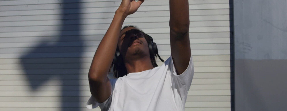 Słuchawki nauszne URBANISTA Los Angeles ANC, ładowanie solarne, energia ze światła, nieprzerwana muzyka, osoba założonymi słuchawkami nausznymi tańcząca w rytm muzyki