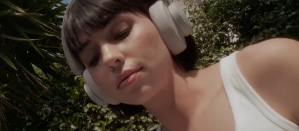 Słuchawki nauszne URBANISTA Los Angeles ANC, aplikacja mobilna, kontrola energii, personalizacja, osoba założonymi słuchawkami nausznymi w plenerze